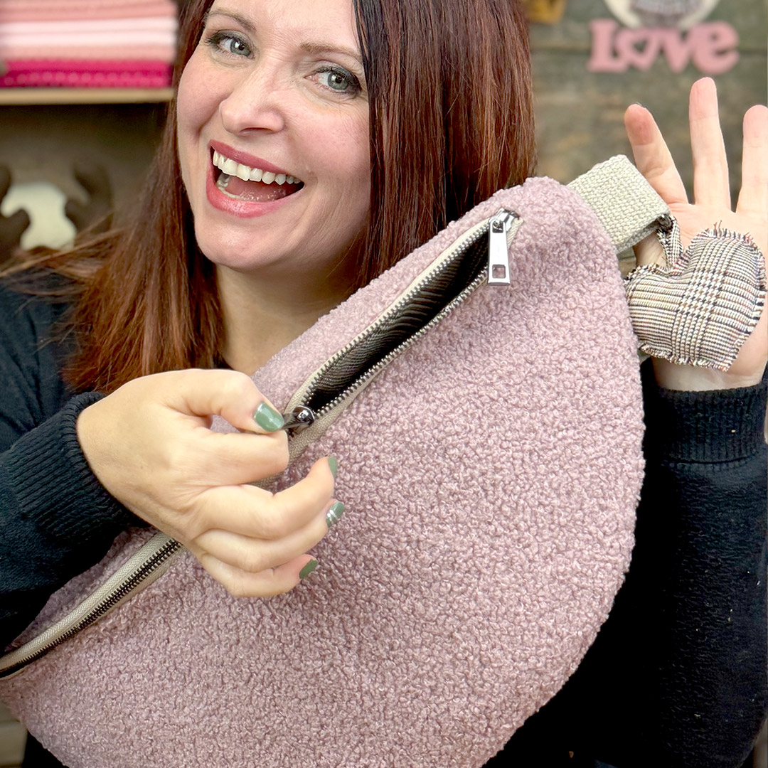 Donna mostra borsa rosa con cerniera aperta