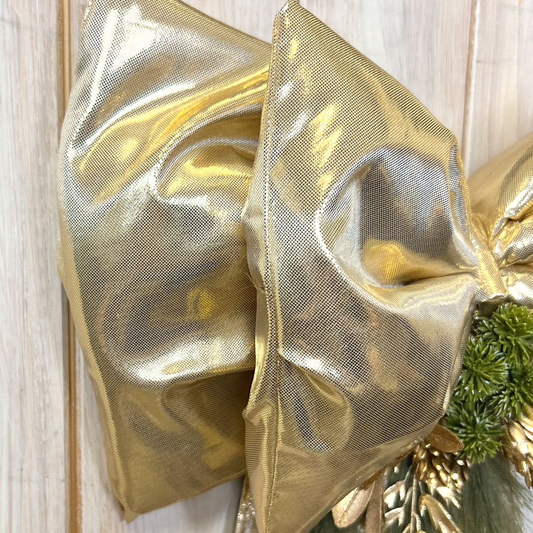 Grande fiocco dorato decorativo su sfondo legno