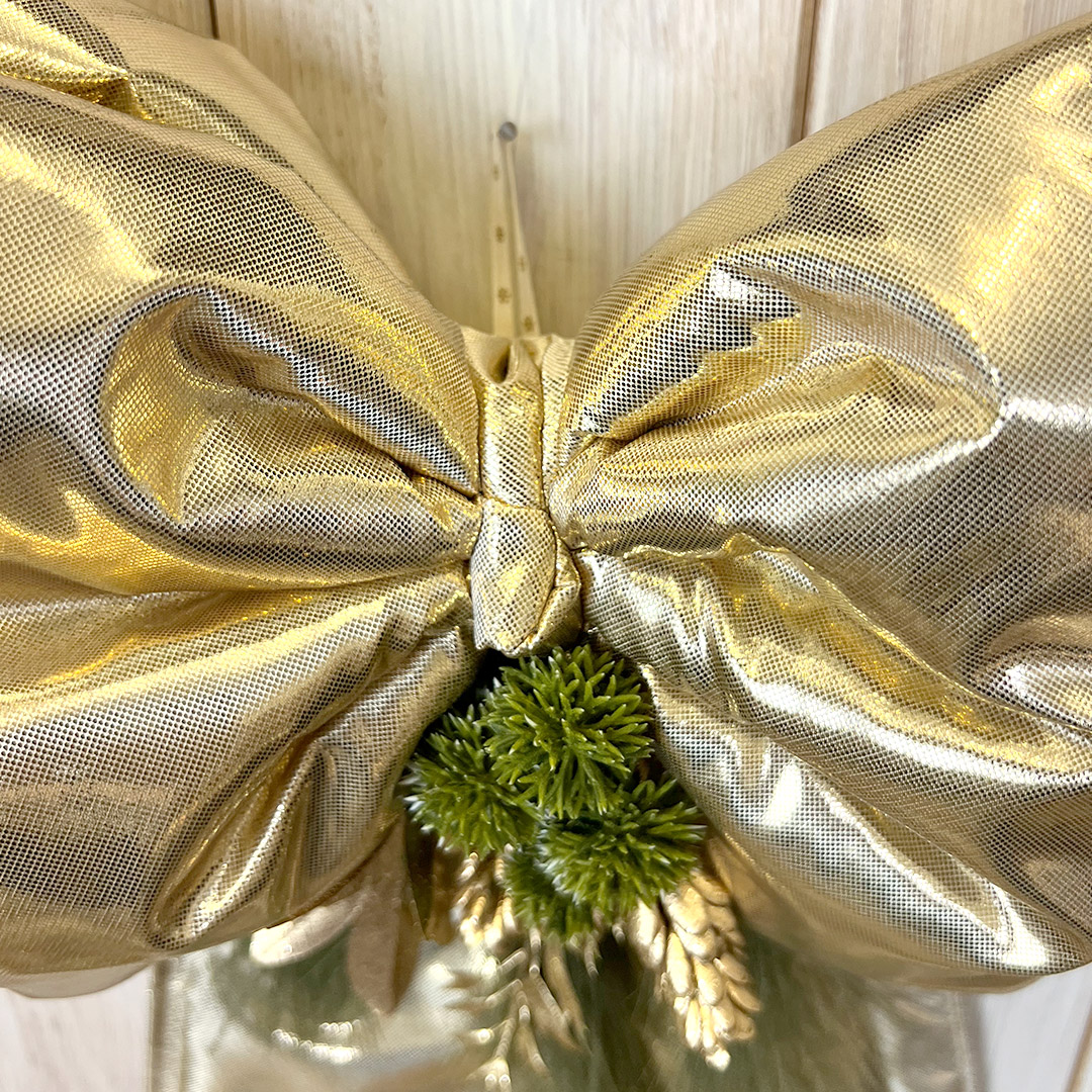 Fiocco dorato decorativo con rami verdi natalizi