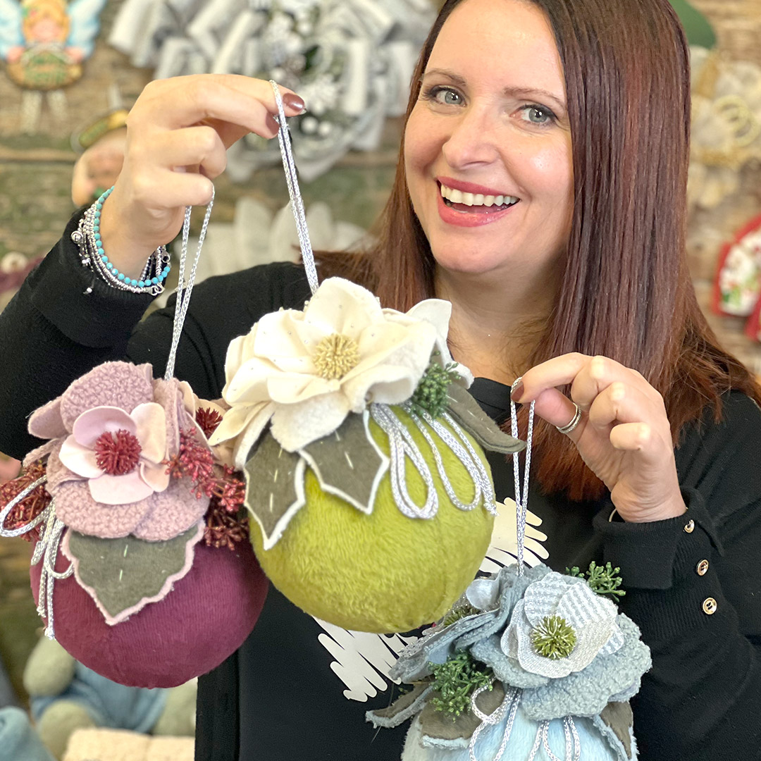 Donna mostra decorazioni floreali fatte a mano