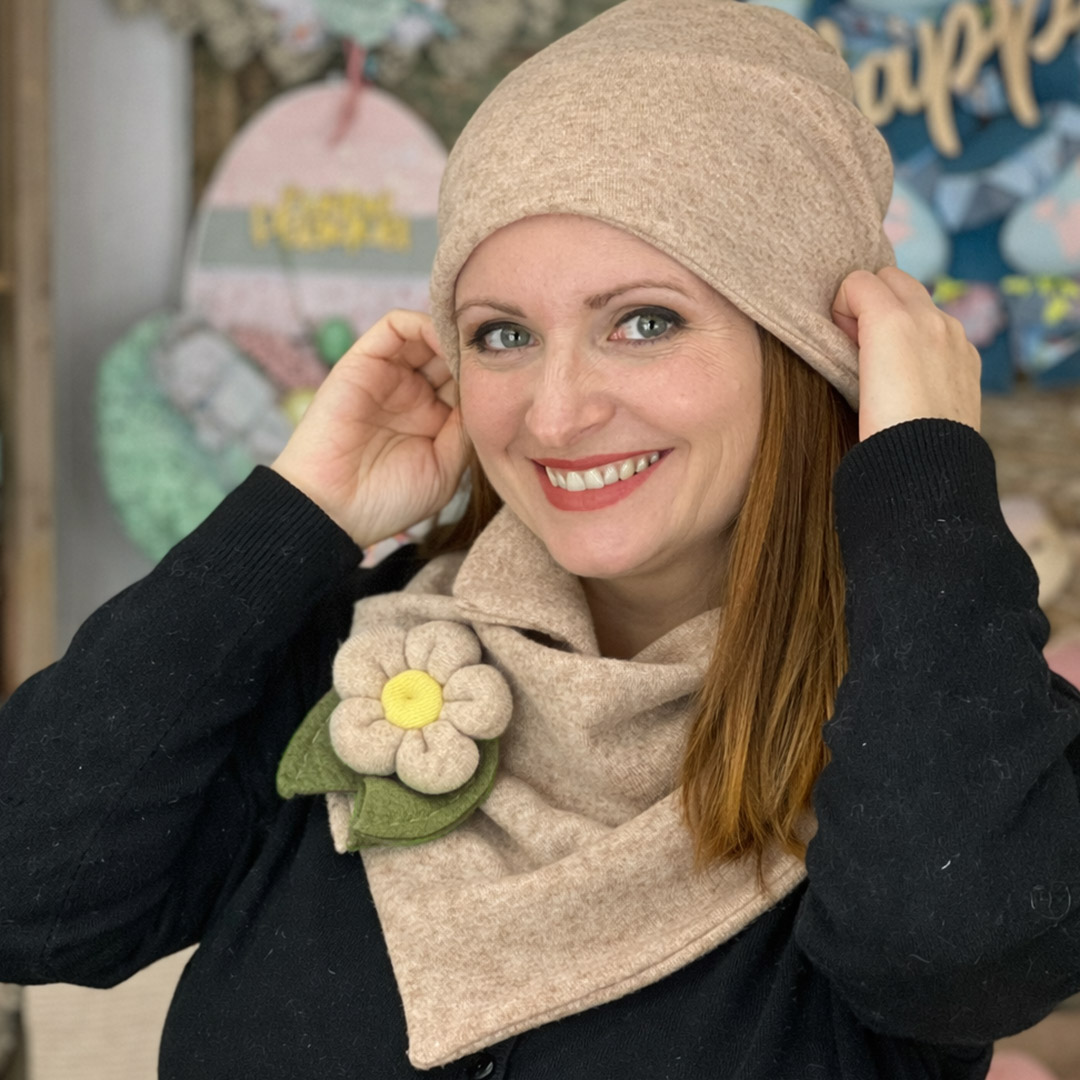 Donna con cappello e sciarpa beige sorridente