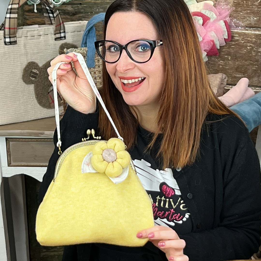Donna mostra borsetta gialla con fiore decorativo