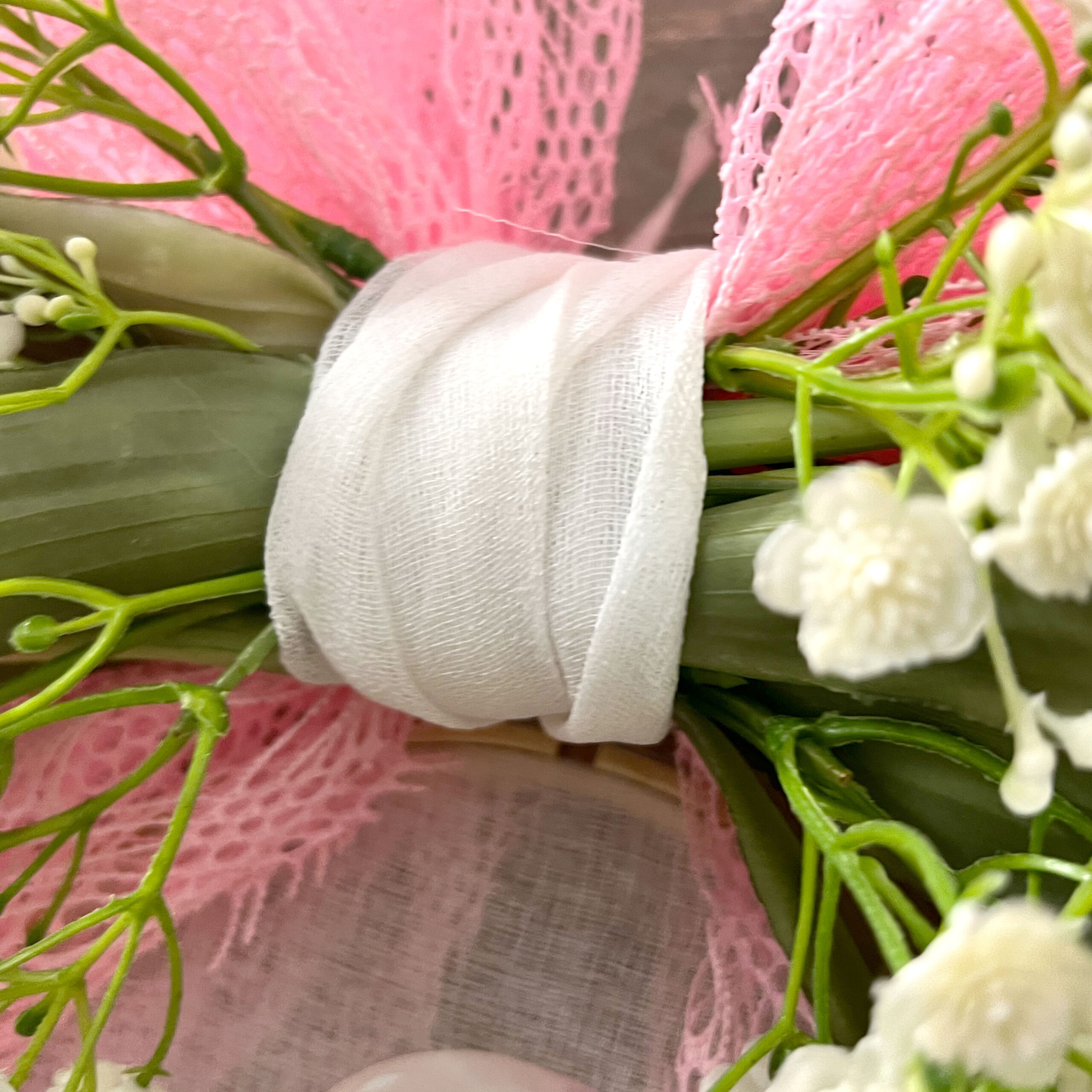 Dettaglio bouquet con gigli rosa e nastro bianco