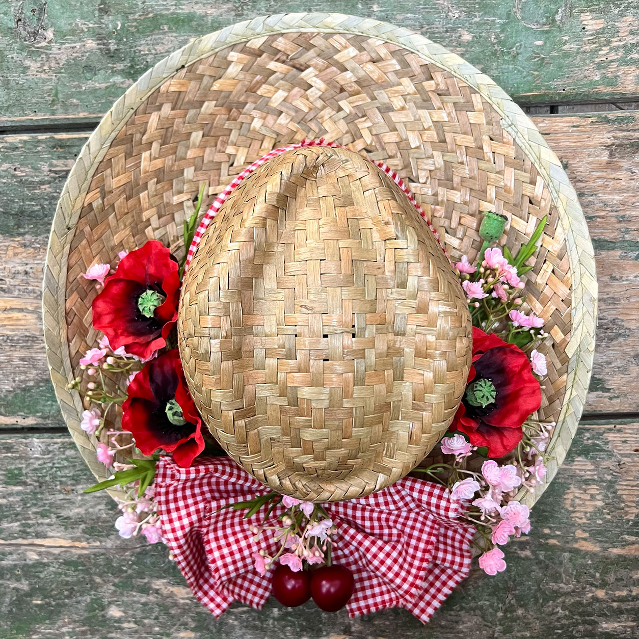 Cappello di paglia con fiori rossi e ciliegie