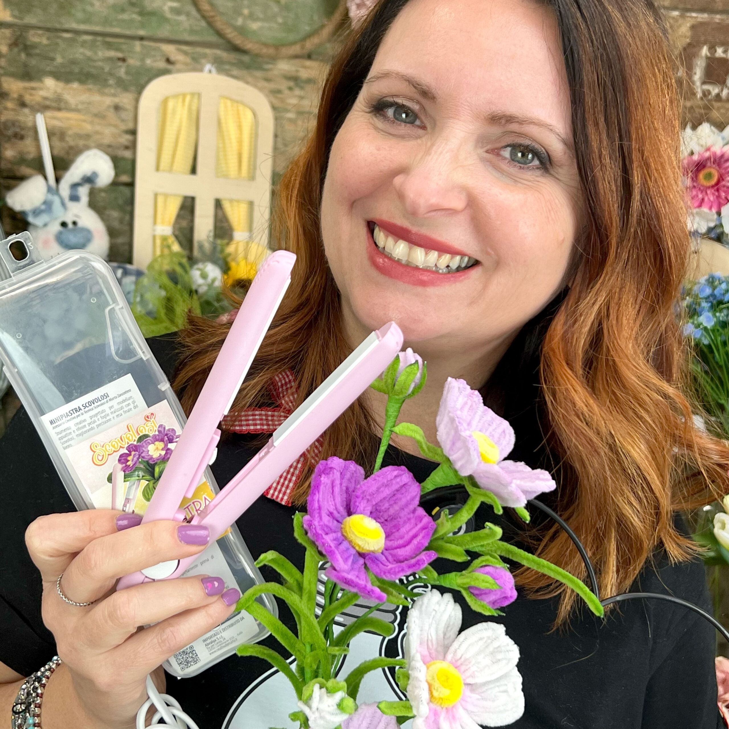 Donna sorridente con mini piastra rosa e fiori