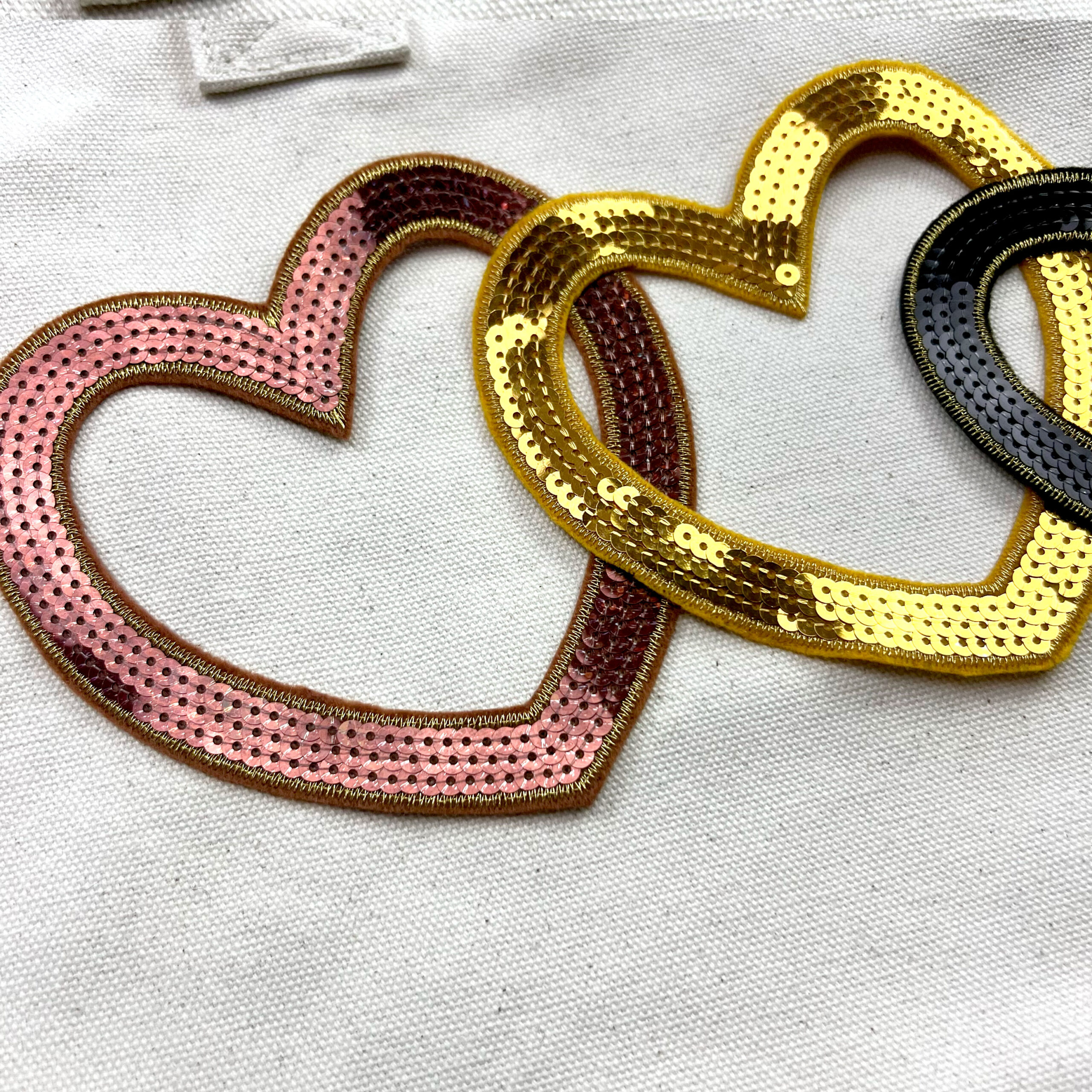 Cuori ricamati con paillettes su tessuto chiaro