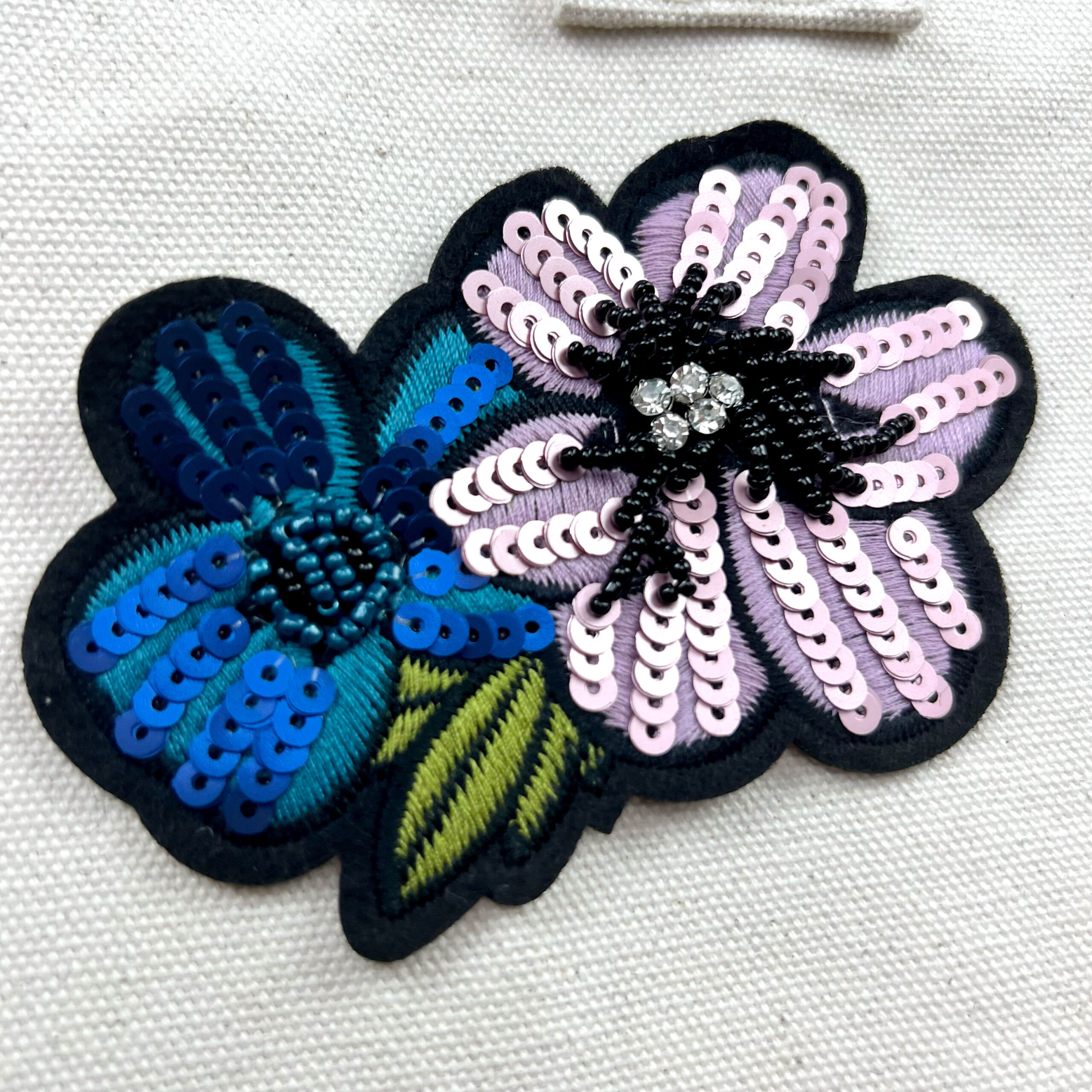 Fiori ricamati con paillettes su tessuto chiaro
