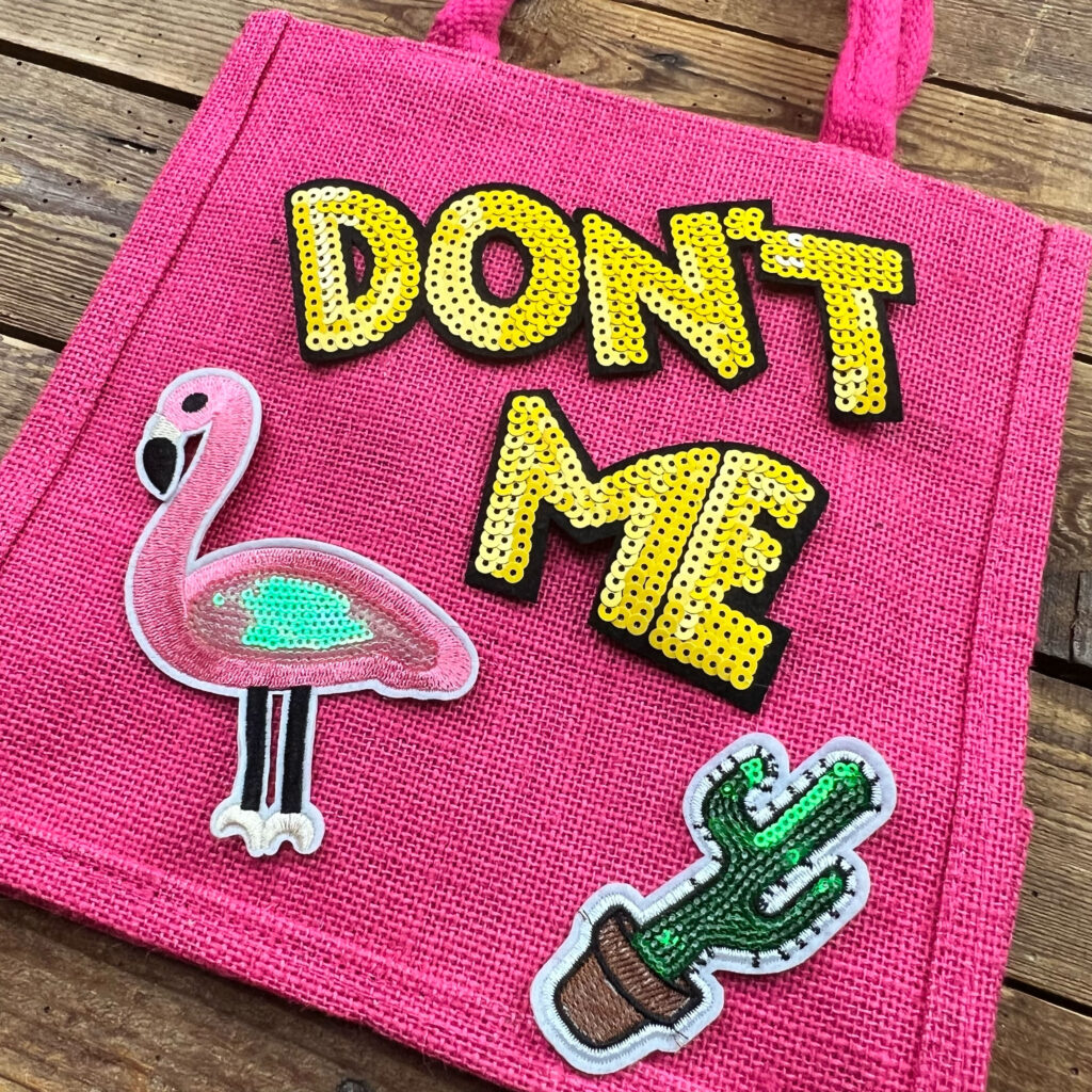Borsa rosa con scritta glitter e toppe decorative