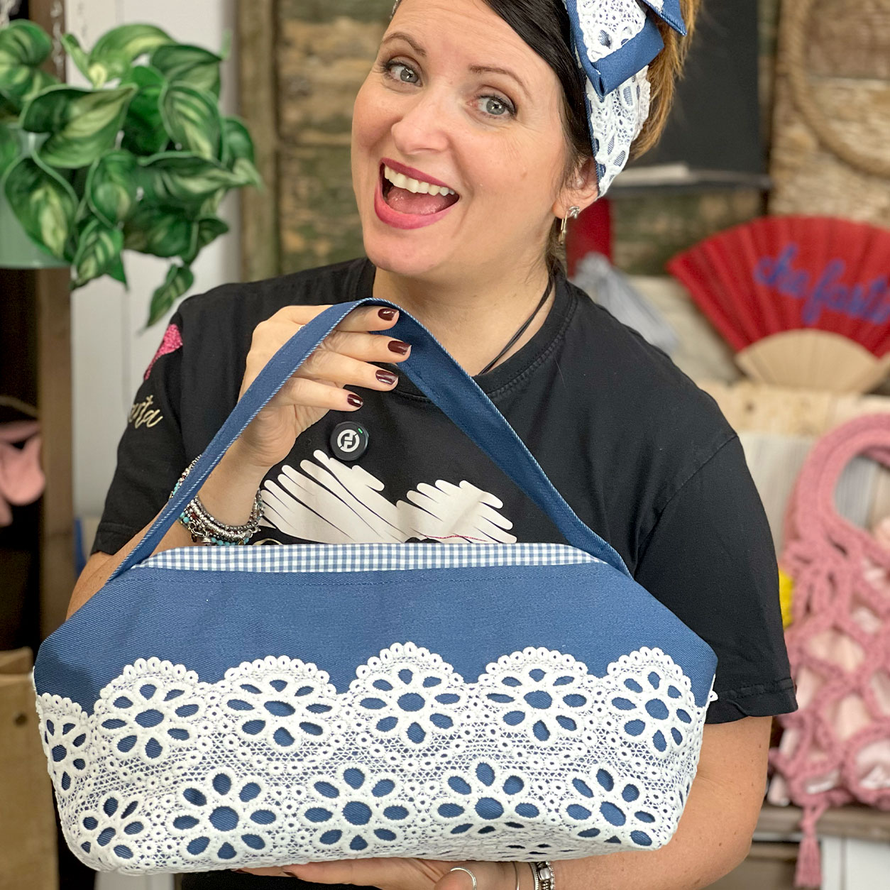 Donna sorridente mostra borsa blu con pizzo bianco