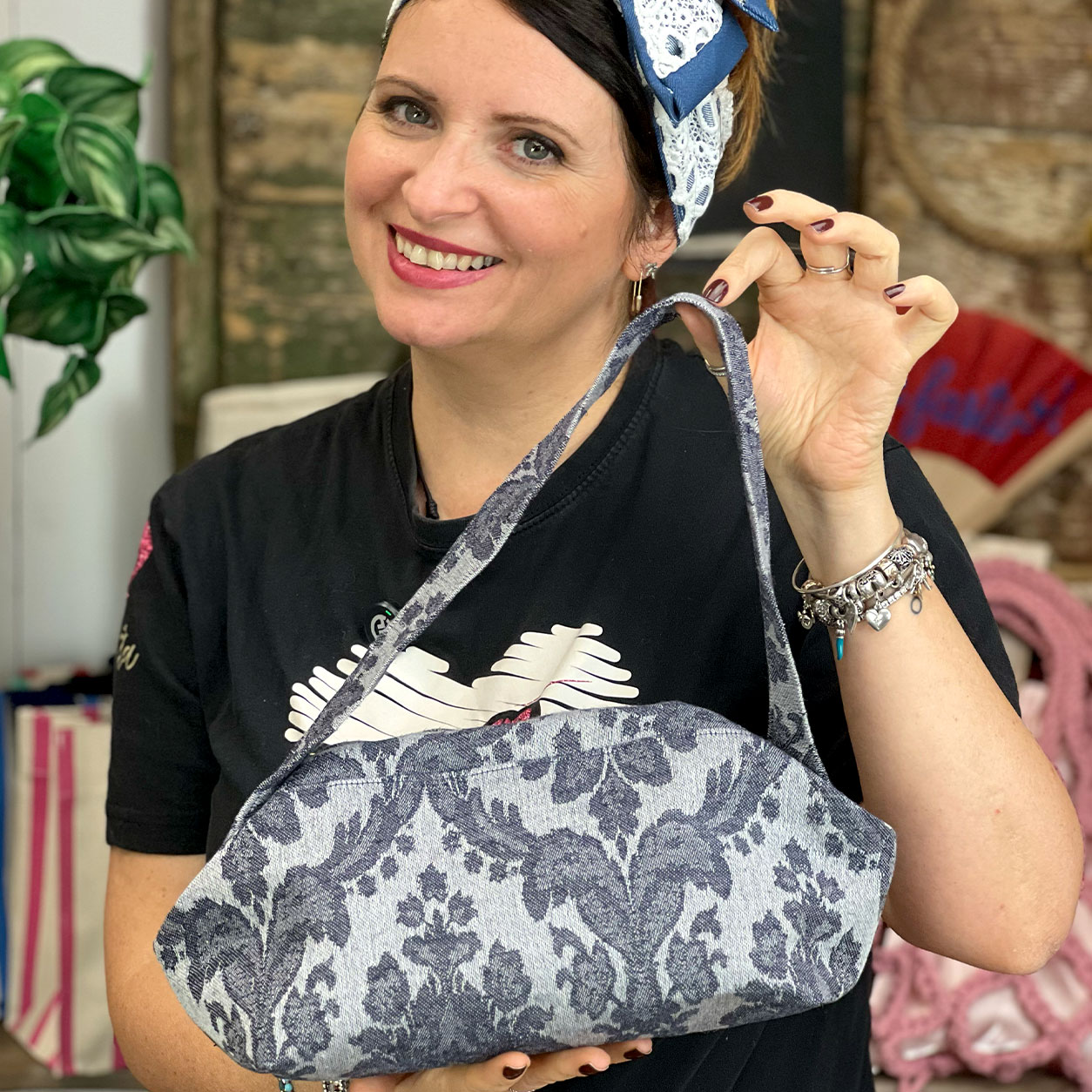 Donna sorridente mostra borsa floreale in tessuto